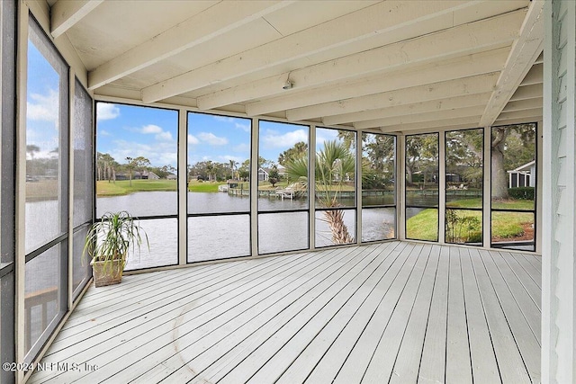 unfurnished sunroom featuring beamed ceiling and a water view