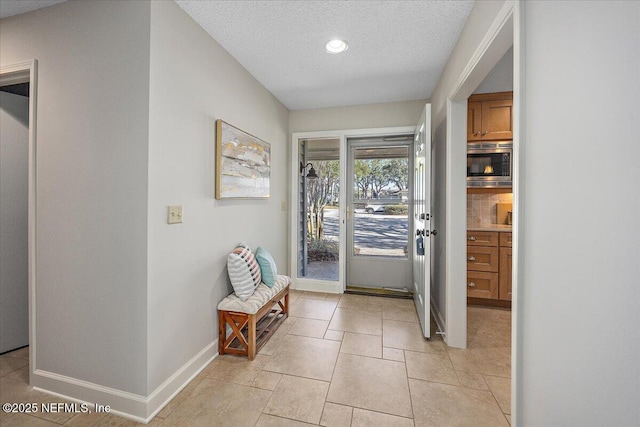 doorway to outside with a textured ceiling