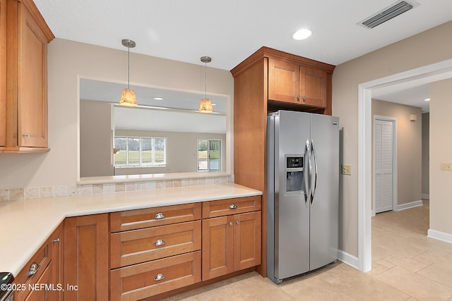 kitchen with decorative light fixtures and stainless steel fridge with ice dispenser