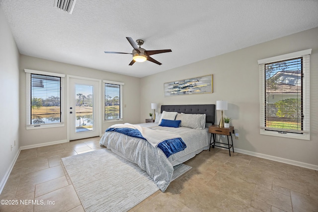 bedroom with ceiling fan, access to outside, and a textured ceiling