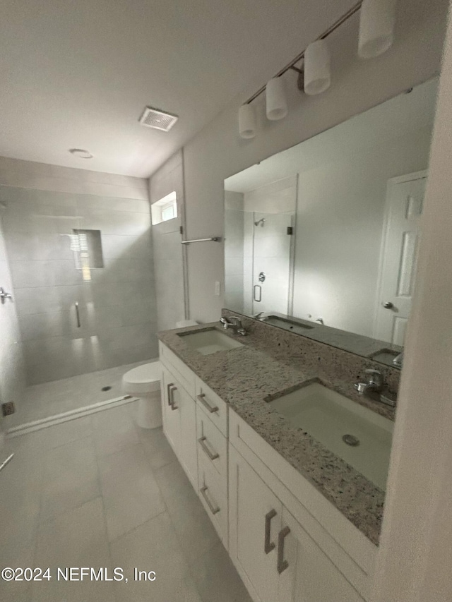 bathroom with tile patterned flooring, toilet, an enclosed shower, and vanity