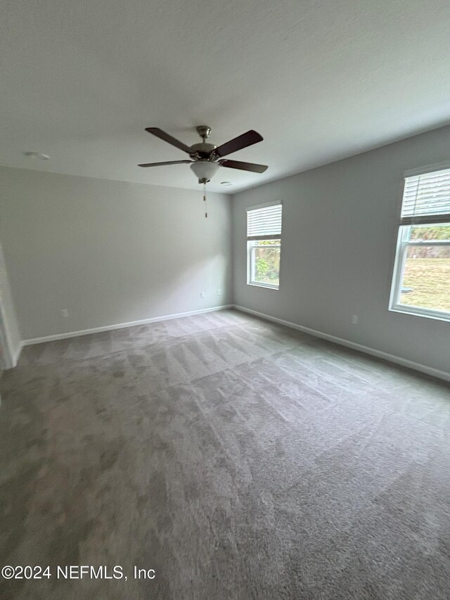 carpeted empty room featuring ceiling fan