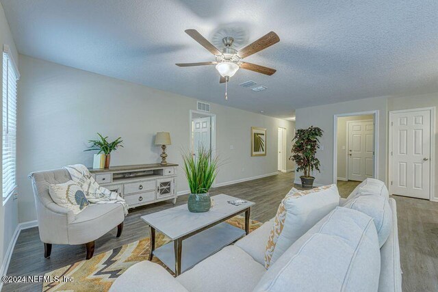 living room featuring a textured ceiling, hardwood / wood-style flooring, and ceiling fan