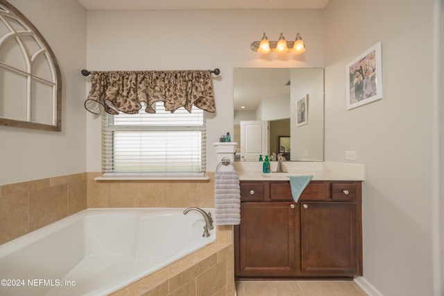 bathroom featuring tiled bath, tile patterned flooring, and vanity