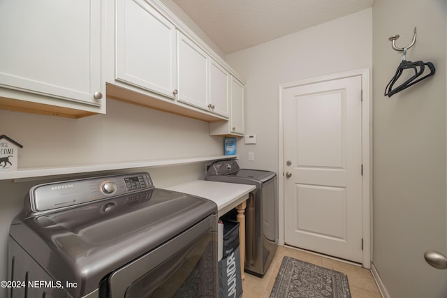 washroom featuring cabinets, separate washer and dryer, and light tile patterned flooring