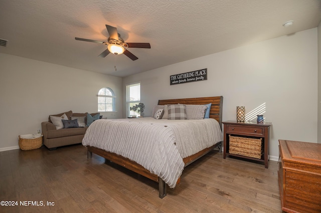 bedroom featuring hardwood / wood-style flooring, ceiling fan, and a textured ceiling