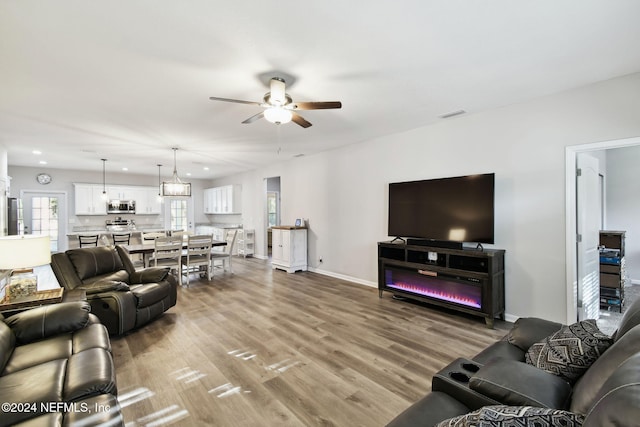 living room with ceiling fan and hardwood / wood-style floors