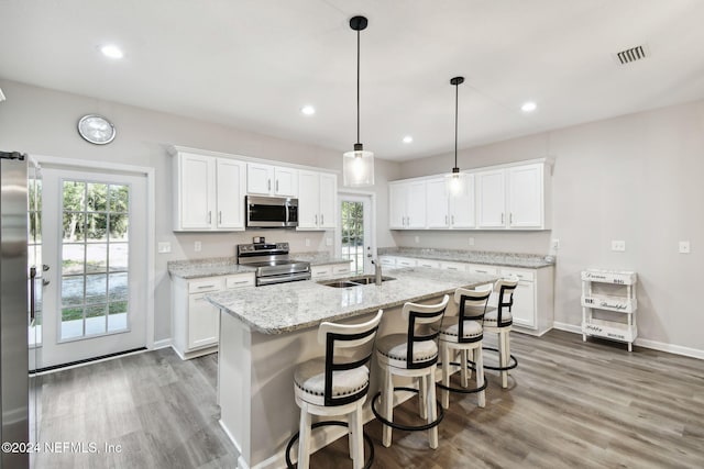 kitchen with hardwood / wood-style flooring, sink, white cabinetry, and stainless steel appliances