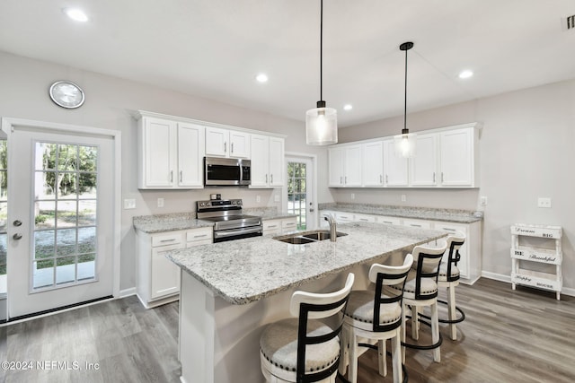 kitchen featuring white cabinets, appliances with stainless steel finishes, a healthy amount of sunlight, and sink