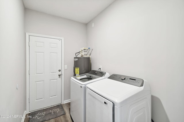 laundry room with separate washer and dryer, electric water heater, and dark hardwood / wood-style flooring