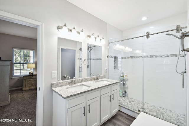 bathroom with hardwood / wood-style flooring, vanity, and walk in shower