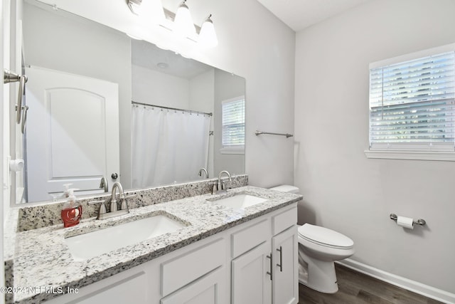 bathroom with hardwood / wood-style floors, vanity, a shower with shower curtain, and toilet