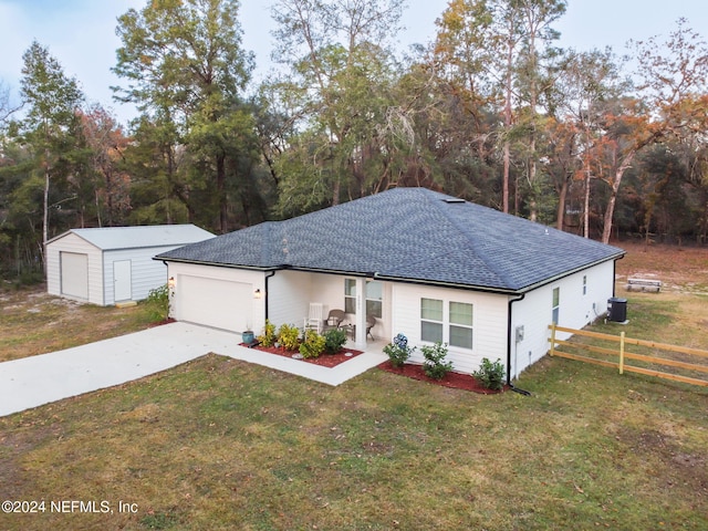 single story home with central air condition unit, a front lawn, and a garage