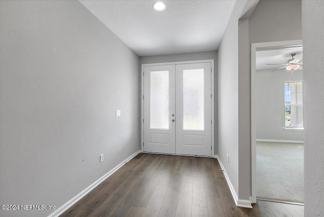 entryway with ceiling fan, french doors, dark wood-type flooring, and a textured ceiling