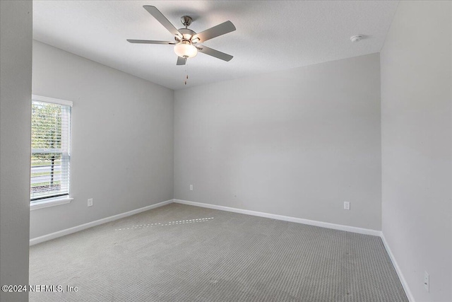 spare room with carpet, ceiling fan, and a textured ceiling