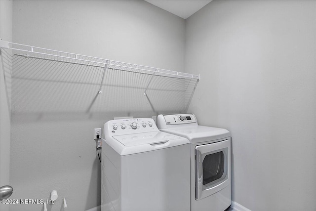 clothes washing area with washing machine and dryer