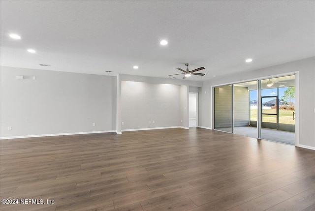 empty room with a textured ceiling, dark hardwood / wood-style floors, and ceiling fan