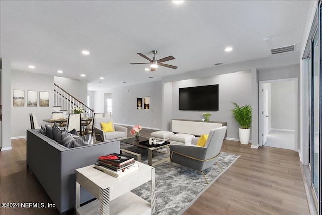 living room featuring light hardwood / wood-style floors and ceiling fan