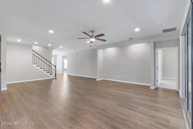 empty room with ceiling fan and light hardwood / wood-style flooring