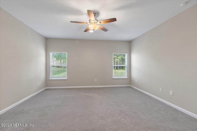 carpeted spare room with ceiling fan and a textured ceiling