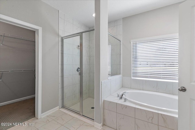 bathroom featuring shower with separate bathtub