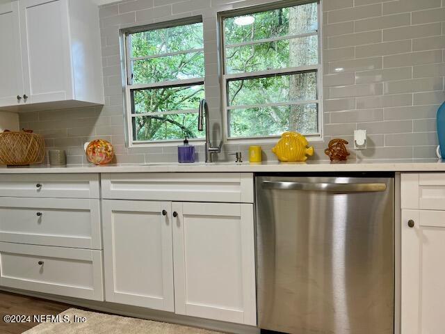 kitchen featuring white cabinetry, dishwasher, sink, and decorative backsplash