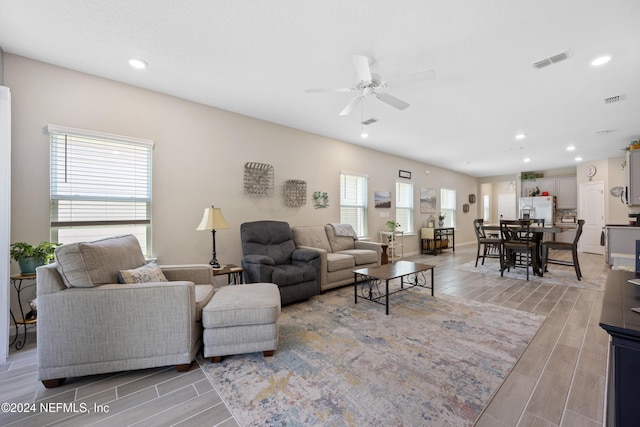 living room with ceiling fan and light hardwood / wood-style flooring