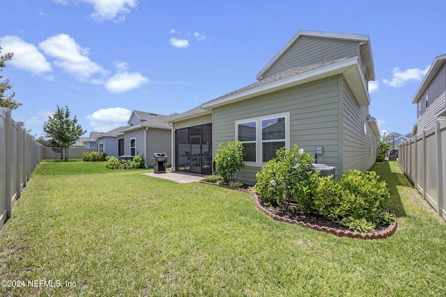 back of house featuring a yard and central AC unit