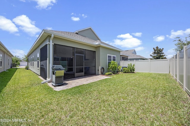 back of house with a yard, a patio area, and a sunroom