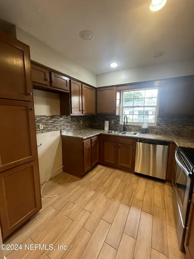 kitchen featuring backsplash, light hardwood / wood-style flooring, stainless steel appliances, and sink