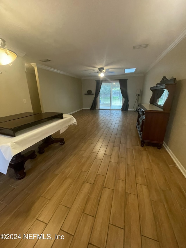 interior space featuring light wood-type flooring, ceiling fan, and crown molding