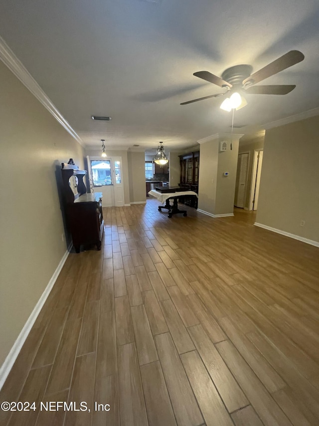 unfurnished living room featuring hardwood / wood-style flooring, ceiling fan, and crown molding