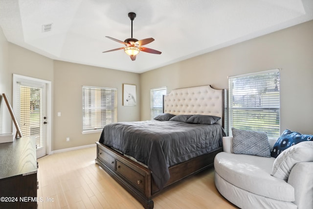 bedroom featuring multiple windows, ceiling fan, light hardwood / wood-style floors, and access to exterior