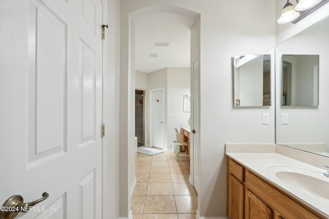 bathroom featuring tile patterned floors, vanity, and a textured ceiling