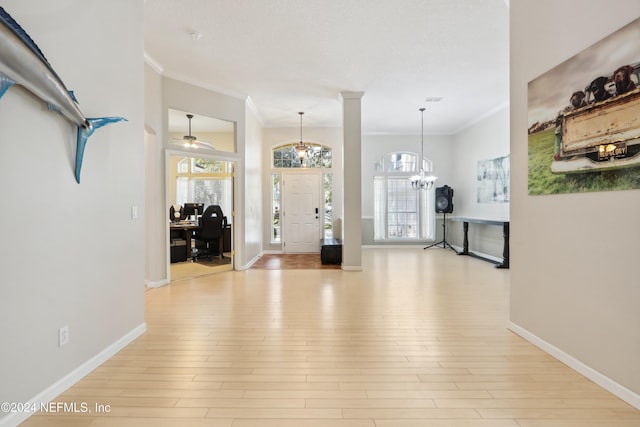 entrance foyer with ceiling fan with notable chandelier, light hardwood / wood-style flooring, and ornamental molding