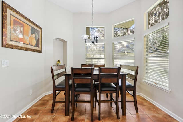 dining space with tile patterned flooring and an inviting chandelier