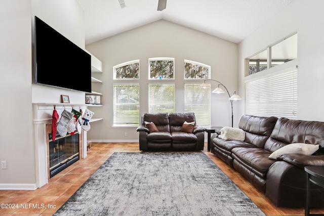 living room featuring a tiled fireplace, tile patterned flooring, and lofted ceiling