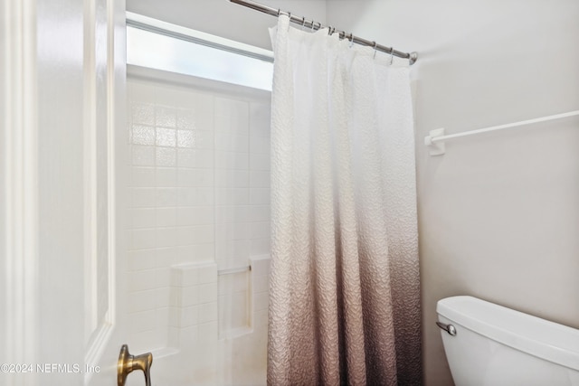 bathroom with shower / tub combo and toilet