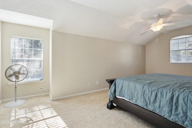 carpeted bedroom featuring a textured ceiling, ceiling fan, and vaulted ceiling