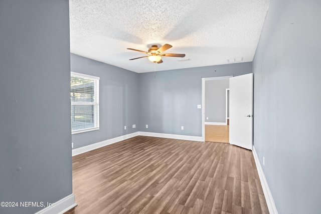 spare room with hardwood / wood-style floors, ceiling fan, and a textured ceiling