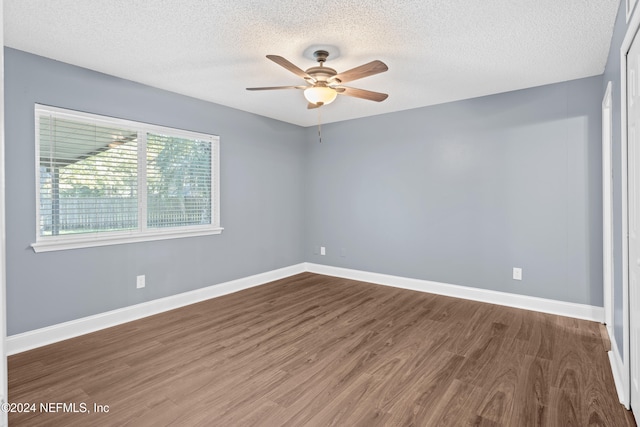 empty room with ceiling fan, wood-type flooring, and a textured ceiling