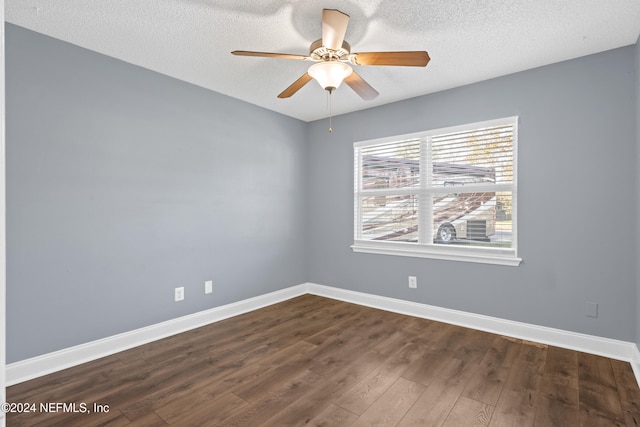 empty room featuring a textured ceiling, ceiling fan, and dark wood-type flooring