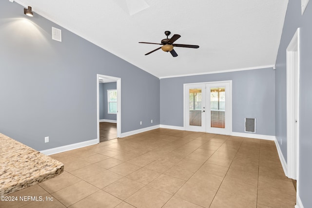 unfurnished living room with french doors, ornamental molding, vaulted ceiling, ceiling fan, and light tile patterned floors