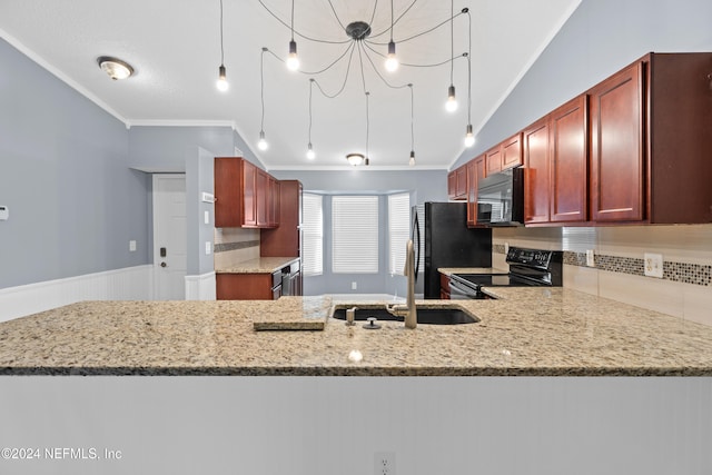 kitchen featuring kitchen peninsula, decorative light fixtures, light stone counters, and black appliances