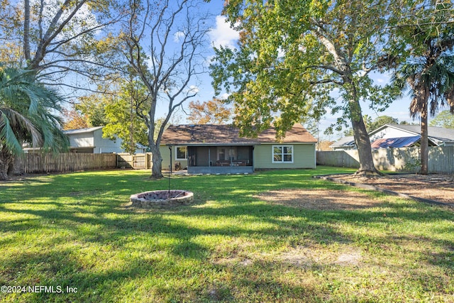 view of yard featuring a sunroom and an outdoor fire pit