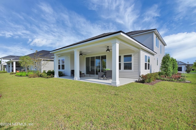 back of property featuring ceiling fan, a patio area, and a lawn