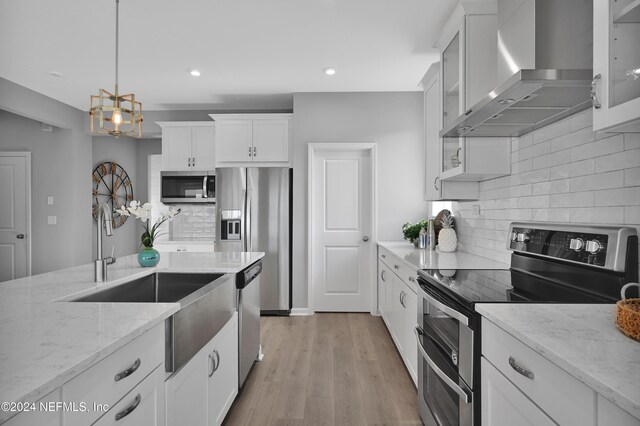 1024 Creighton Rd, Fleming Island, FL 32003 - kitchen with appliances with stainless steel finishes, wall chimney exhaust hood, white cabinets, backsplash, and a sink