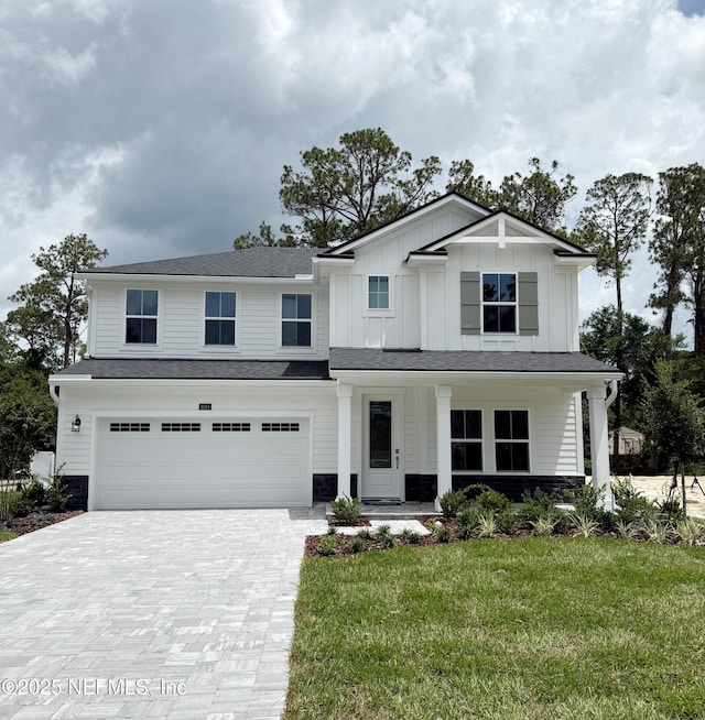 1024 Creighton Rd, Fleming Island, FL 32003 - view of front of house with a garage, decorative driveway, a front yard, covered porch, and board and batten siding