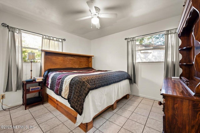 bedroom featuring multiple windows, ceiling fan, and light tile patterned floors