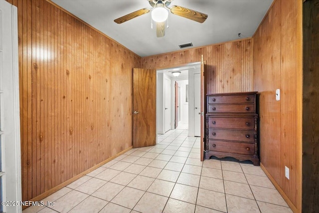 hall with wood walls and light tile patterned floors